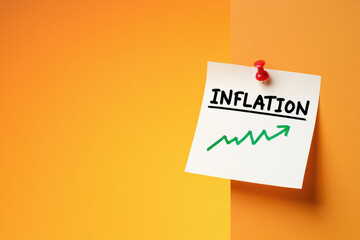 Inflationary Pressures A Visual Representation of Rising Costs with a Note Displaying Inflation and an Upward Trending Arrow Pinned Against a Two Toned Orange Background