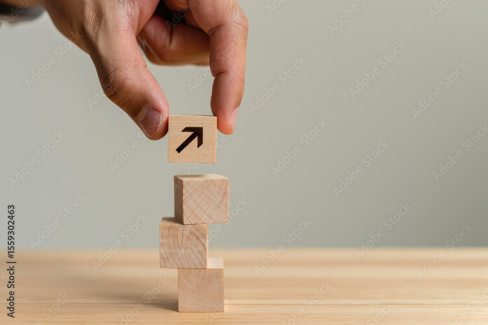 Poster stacking success a hand places a block with an upward arrow on a tower of blocks symbolizing growth,