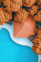 A terracotta-roofed building is surrounded by orange trees next to a blue pool. Aerial view, color contrast, modern architecture