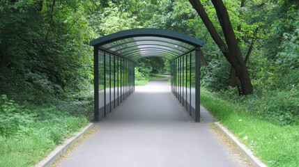 A covered walkway stretches through a lush green park, surrounded by trees. Tranquil pathway in a park