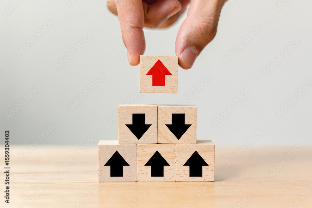 Poster elevating success a hand placing a wooden block with an upward arrow atop a pyramid of blocks with d