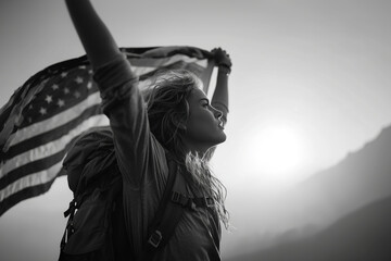 Woman holds up US flag outdoors in grayscale.. A patriotic portrait of freedom and hope.. National pride, American spirit, monochrome. Independence Day. Fourth of July.