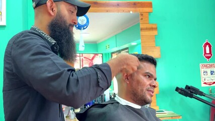 Hairdresser cutting hair of client in barbershop