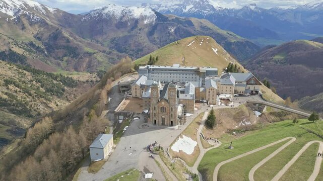 Close-up of the Basilica of Our Lady of La Salette in the French Alps, surrounded by lush forests and snowy mountains. Site of the 1846 Marian apparitions.