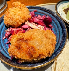 Deep fried food on small dish with red pickles