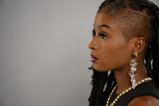 Confident Close-Up Portrait of Young African-American Woman with Locs and Bold Accessories