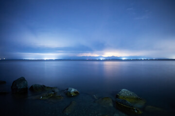 Beautiful night landscape , lake and stones  with long exposure clouds, starry sky.