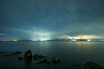 Beautiful night landscape , lake and stones  with long exposure clouds, starry sky.