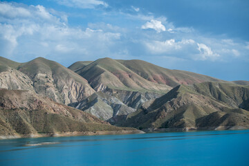 Landscape with small lake and mountain under blue sky.