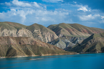 Landscape with small lake and mountain under blue sky.