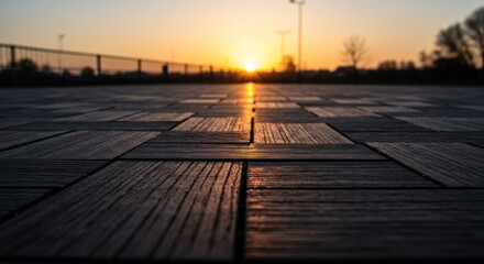 Sunset or sunrise over a wooden surface with a fence and trees.