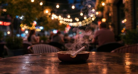 Burning Cigarette in Ashtray on Wooden Table at Night with Bokeh Lights