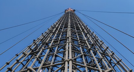 Tall structure with ropes and cables against a blue sky