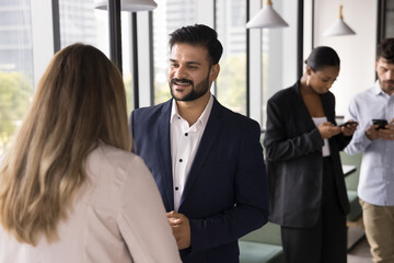 Informal professional interaction. Confident relaxed multiracial businesspeople have casual talks...