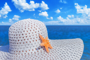 Close-up view of a sun hat on a beach by the sea, selective focus. Beach holiday concept, background with copy space for text