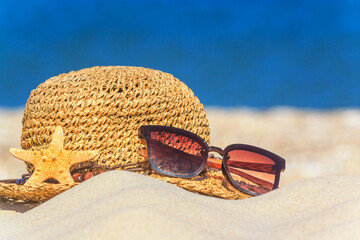 Close-up view of a sun hat on a sandy beach by the sea, selective focus. Beach holiday concept,...