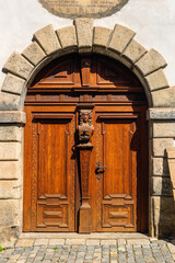 Summer cityscape - view of an antique wooden carved entrance door on Latran street in the historical center of Cesky Krumlov, Czech Republic