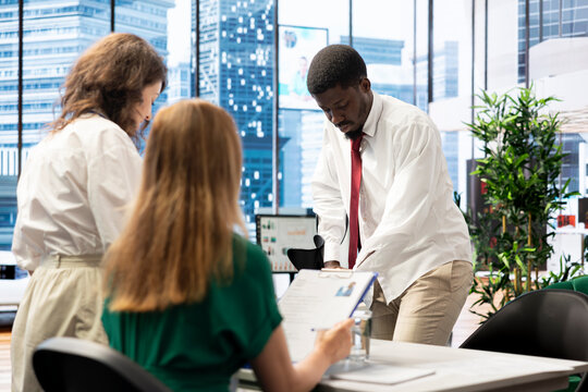 Job interview candidate walking with crutches interested in career advancement, talking with team of HR experts. Man using canes discussing with human resources colleagues to get hired