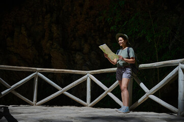 Woman Exploring Hiking Trail in Nature Holding Map on Sunny Day