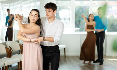 While doing rehearsal of reporting concert, guy and girl participants of dance workshop perform...