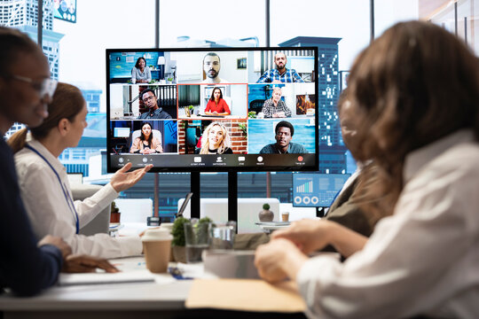 Company employees attending a meeting via videocall with investors, discussing about the future of the enterprise. Advisory board and workers examining infographics data for management.