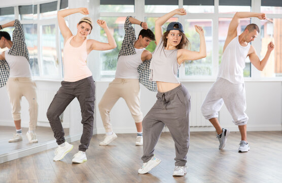 Active young girl practicing basic hip-hop moves in training hall during dancing classes