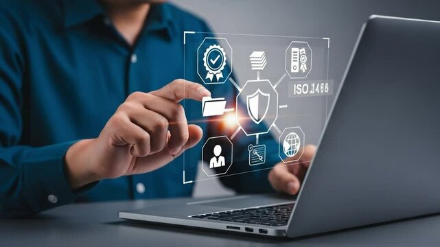 Person interacting with iso standard icons on a laptop screen in a business setting at a desk top - Powered by Adobe