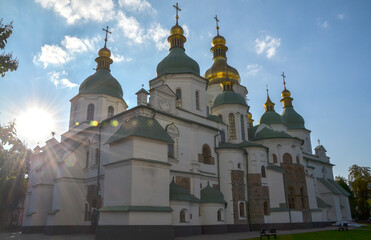 Majestic Orthodox cathedral, St. Sophia's in Kyiv, with its iconic green domes and golden cupolas gleaming under a blue sky with soft clouds