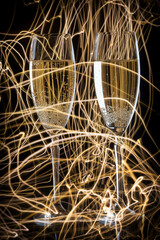 Pair of champagne glasses against backdrop of lights