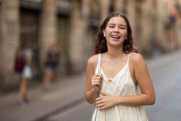 Young woman in white dress walking along the streets of the historical center of the city