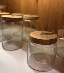 Glass jar with wooden lid for dry food storage. Minimalist kitchen container ideal for organizing...
