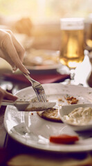 Close-Up of Hands Eating Appetizers at Elegant Restaurant Table