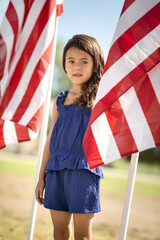 Child girl standing with American flag on 4th of July Independence Day