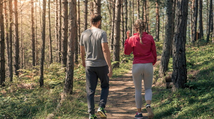 Obraz premium Couple Enjoying a Peaceful Walk Through Forest Trail