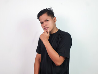 Portrait of Asian man in a black shirt placing hand on chin, expressing thoughtfulness and...