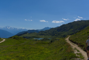 Serene alpine lake with snow-capped mountains and green slopes. Perfect for tranquil nature scenes...