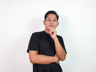 Portrait of a confident young Asian man wearing a black t-shirt, standing on a plain white...
