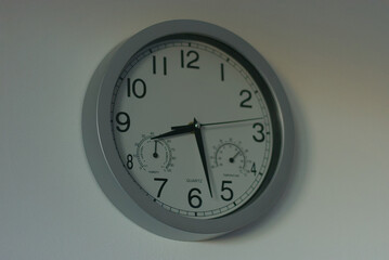A sleek, modern wall clock with integrated temperature and humidity gauges, perfect for tracking...