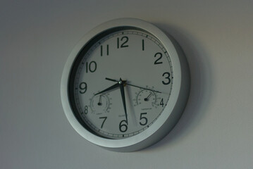 A sleek, modern wall clock with integrated temperature and humidity gauges, perfect for tracking...