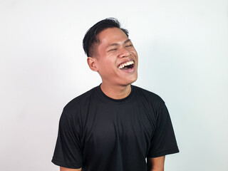 Cheerful Young Man Smiling Brightly Against a White Background. Joyful young man in black shirt...