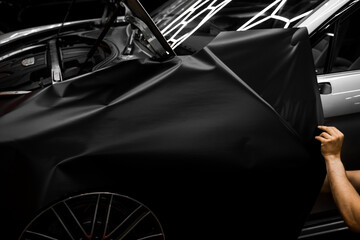 Car Door Panel Wrapping. Process of wrapping car with matte black vinyl and tensioning the...
