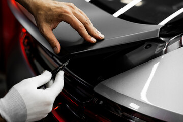 Vinyl Application in Progress in detailing. Vinyl film is trimmed with sharp blade to ensure...