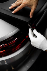 Vinyl Application in Progress in detailing. Vinyl film is trimmed with sharp blade to ensure...