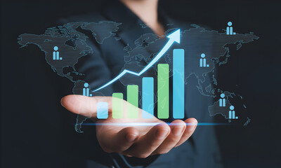 A business professional's hand projects a futuristic holographic world map overlaid with an upward trending growth chart, symbolizing global business