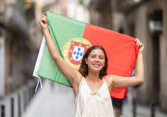 Young woman in summer dress with Portuguese flag on city street