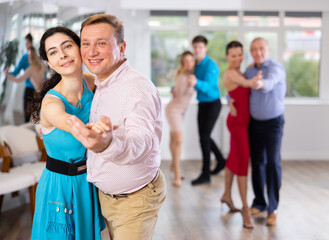 Obraz premium Adult man and young woman dancing in dance class