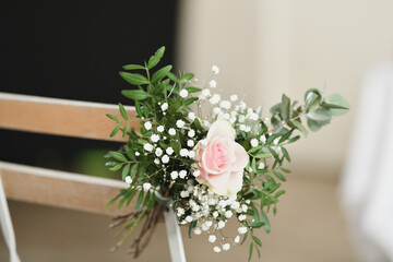 Guest chairs decorated with small bouquets for outdoor wedding ceremony