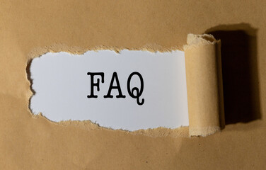 The Text “FAQ” Appearing Behind Torn Brown Paper – Information Access Concept