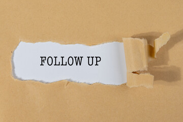 The Text “FOLLOW UP” Appearing Behind Torn Brown Paper – Professional Reminder Concept