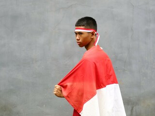 Indonesian young boy in red outfit and red white headband shouted excitedly during Indonesia...